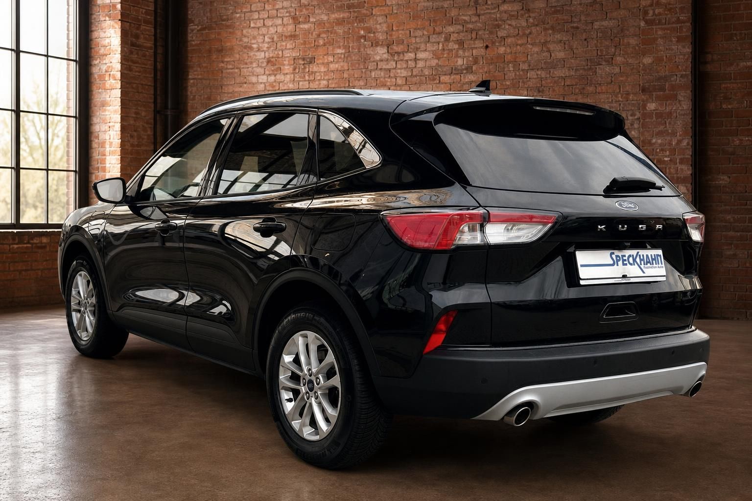 Ford Kuga schwarz Heckansicht seitlich in Loft-Ambiente