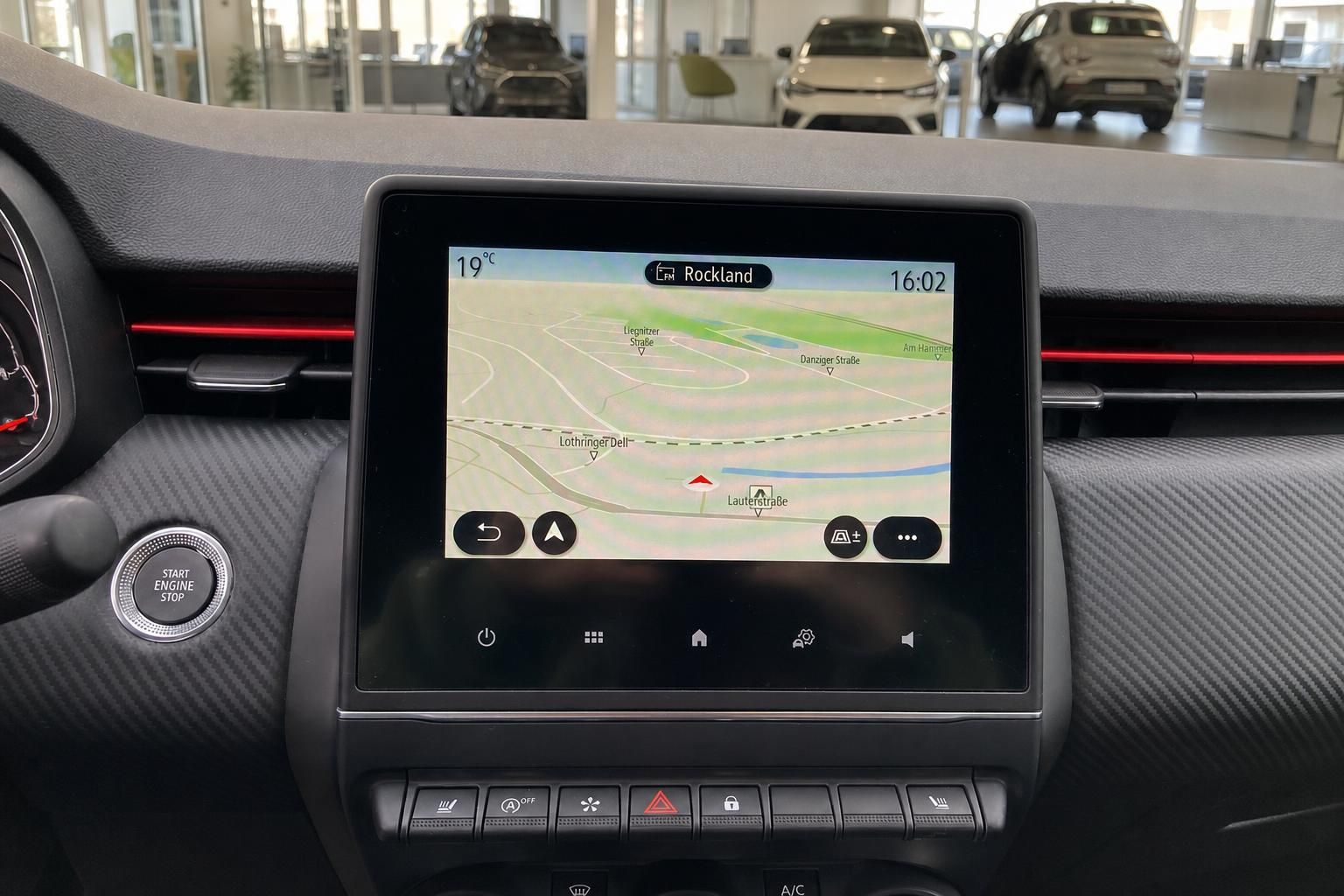 Touchscreen Infotainment System mit Navigationskarte und Bedienungstasten im Auto Innenraum