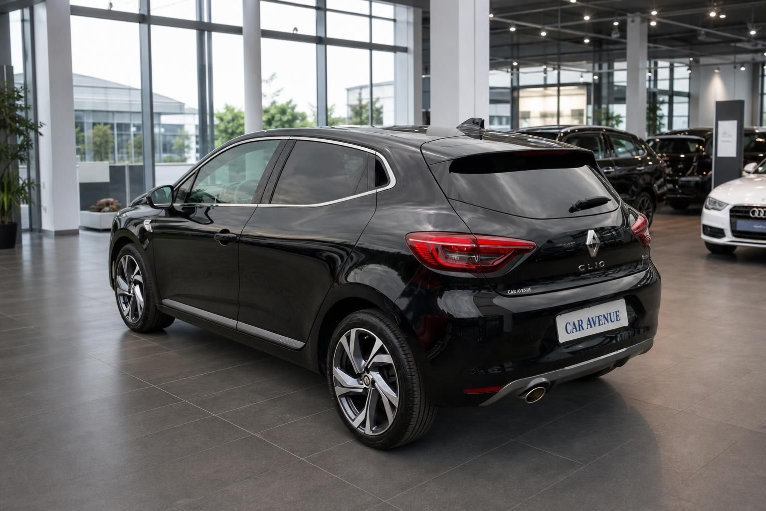 Schwarzer Renault Clio Seitenansicht hinten rechts im Autohaus-Showroom
