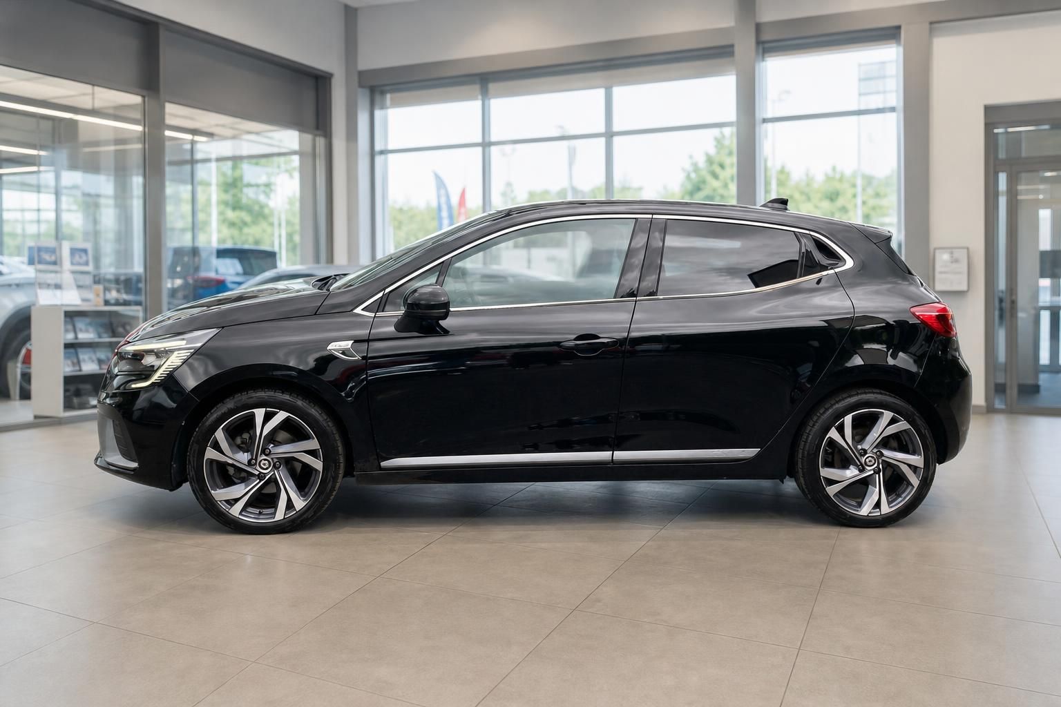 Renault Clio Seitenansicht links - schwarzer Kompaktwagen im modernen Showroom