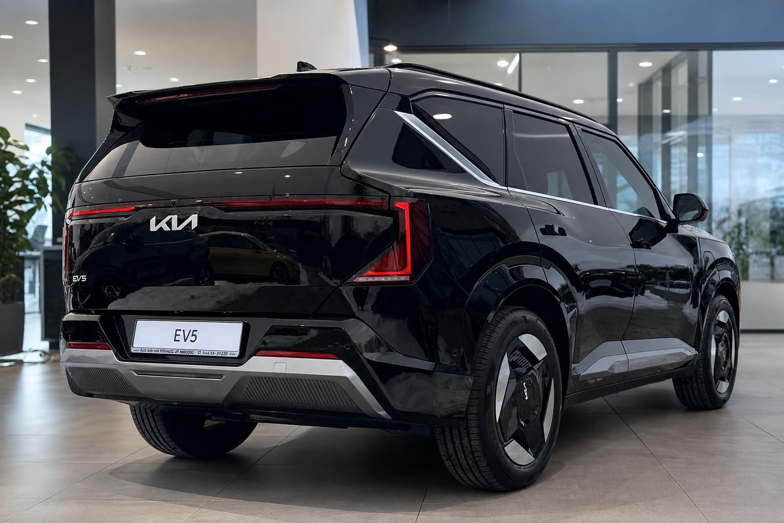 Kia EV5 schwarz, Heck-Seitenansicht im Showroom