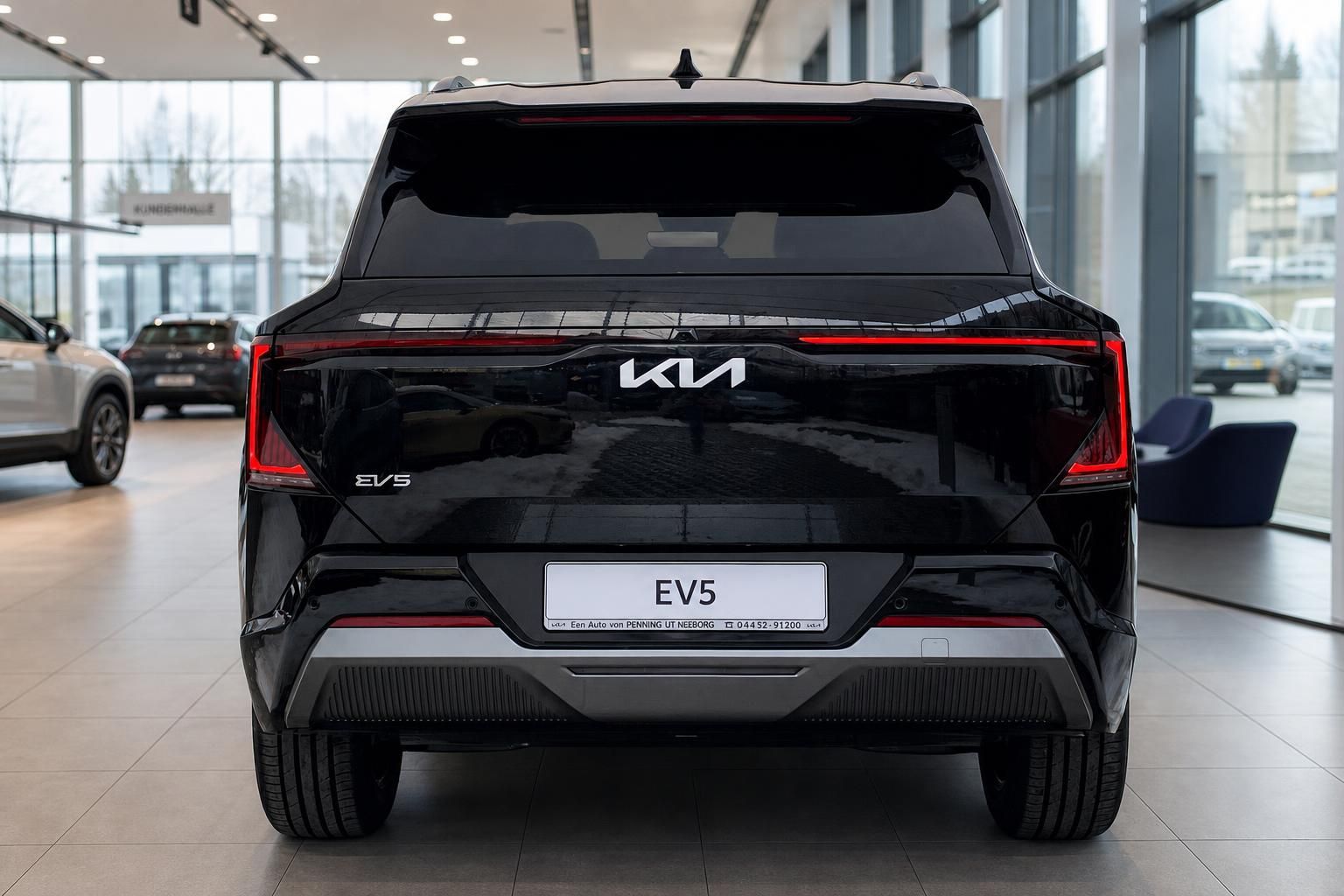 Kia EV5 in Schwarz, Heckansicht im Autohaus-Showroom
