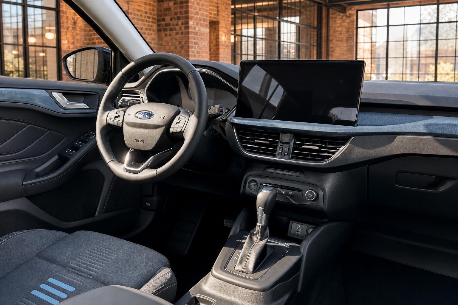 Ford Cockpit mit Lenkrad, großem Touchscreen-Display und Automatikgetriebe in dunklem Interieur