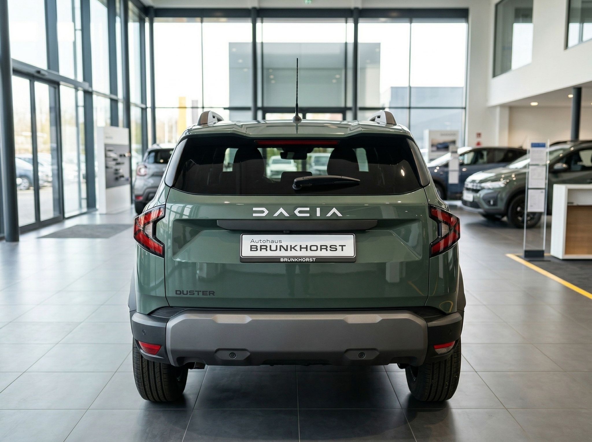 Dacia Duster Heckansicht in grün - SUV von hinten im Autohaus mit DACIA Schriftzug und Kennzeichen
