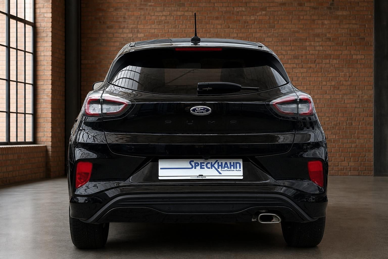 Ford Puma schwarz direkte Heckansicht mit Ford-Logo und Auspuff im Showroom