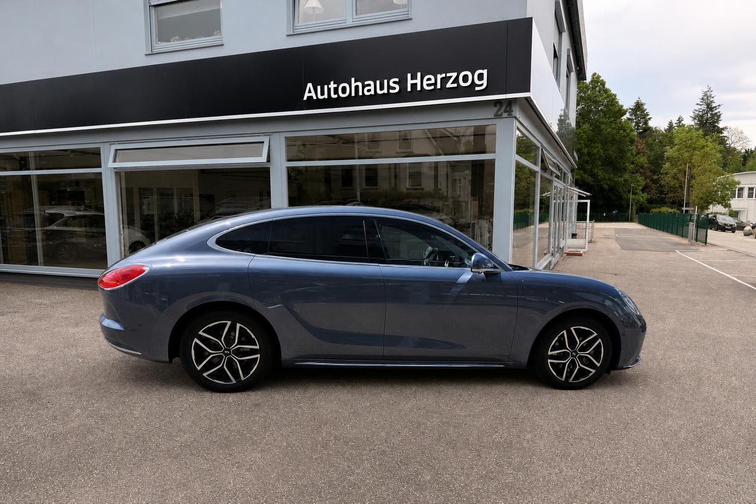 Blauer Porsche Panamera Seitenansicht vor Autohaus Herzog - moderne Sportwagenlimousine mit Leichtmetallfelgen