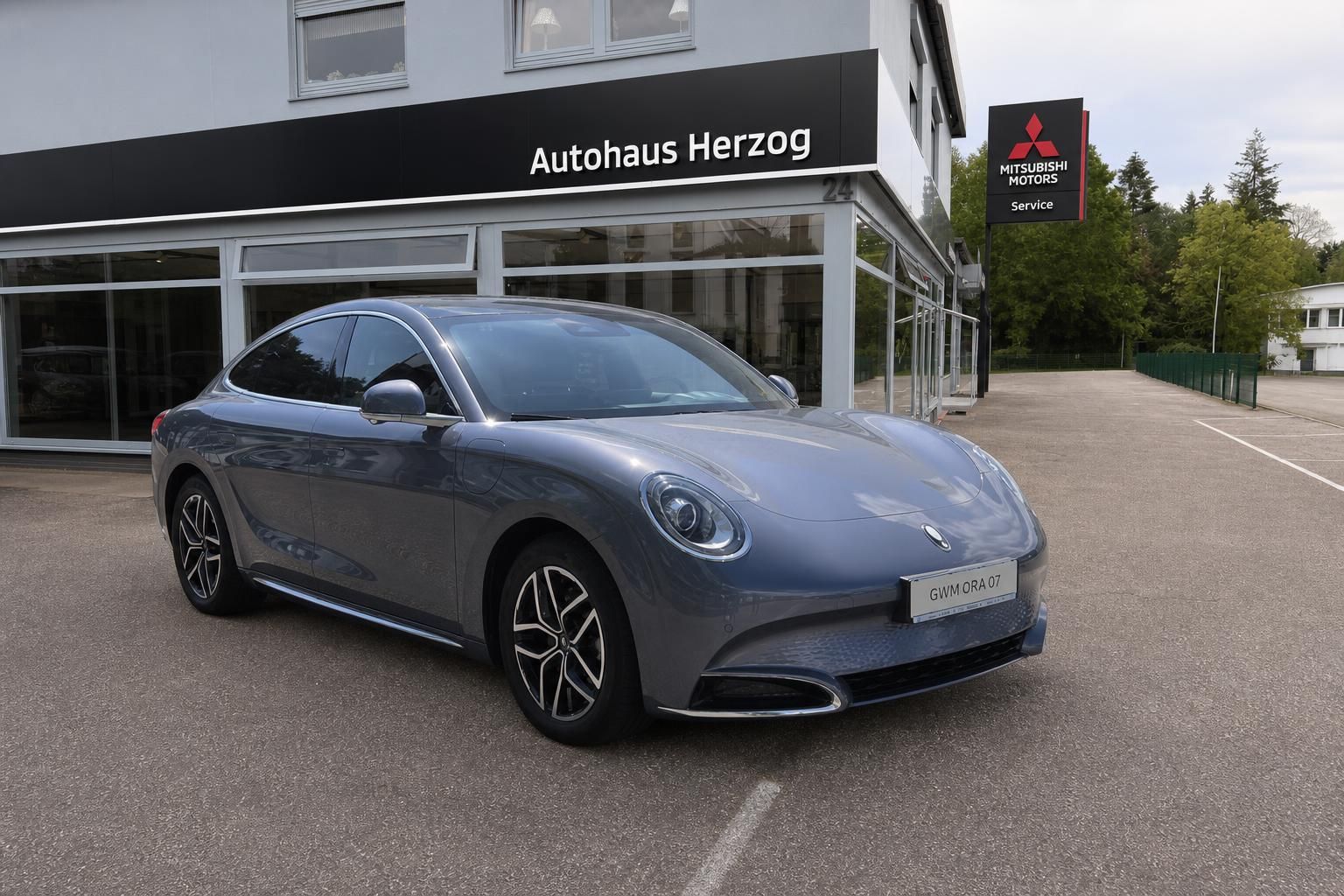Grauer Porsche Fahrzeug Frontansicht vor Autohaus Herzog - elegante Sportwagen Außenaufnahme mit Kennzeichen