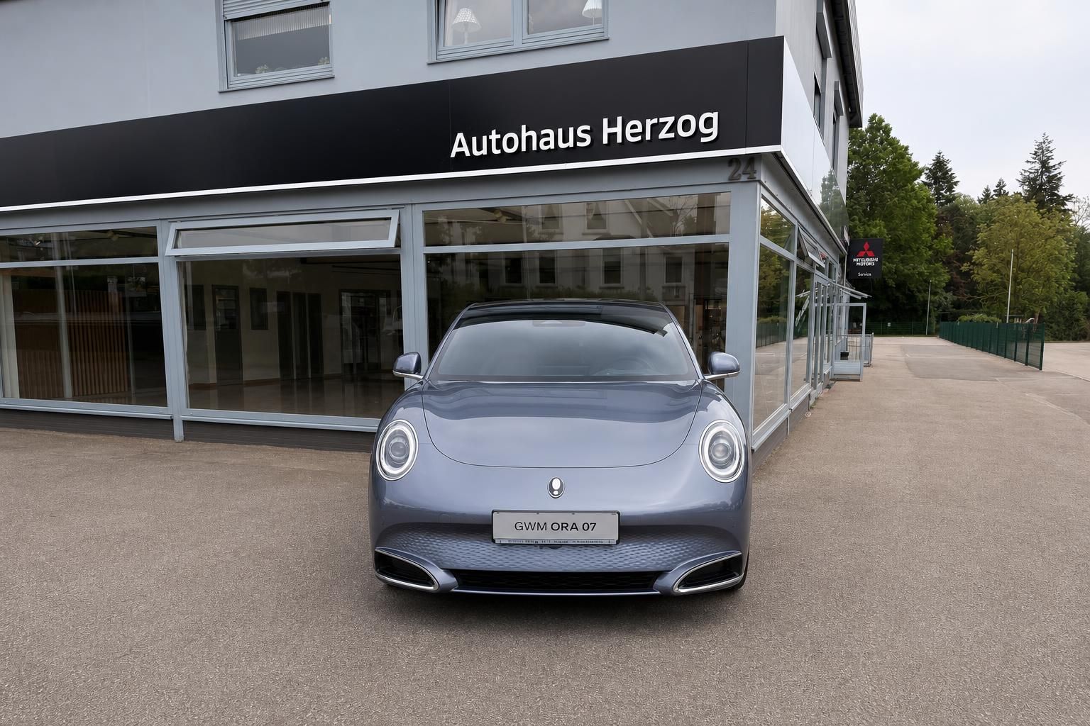 Blauer Porsche Frontansicht vor Autohaus Herzog - moderne Sportwagen Front mit LED-Scheinwerfern und Kennzeichen