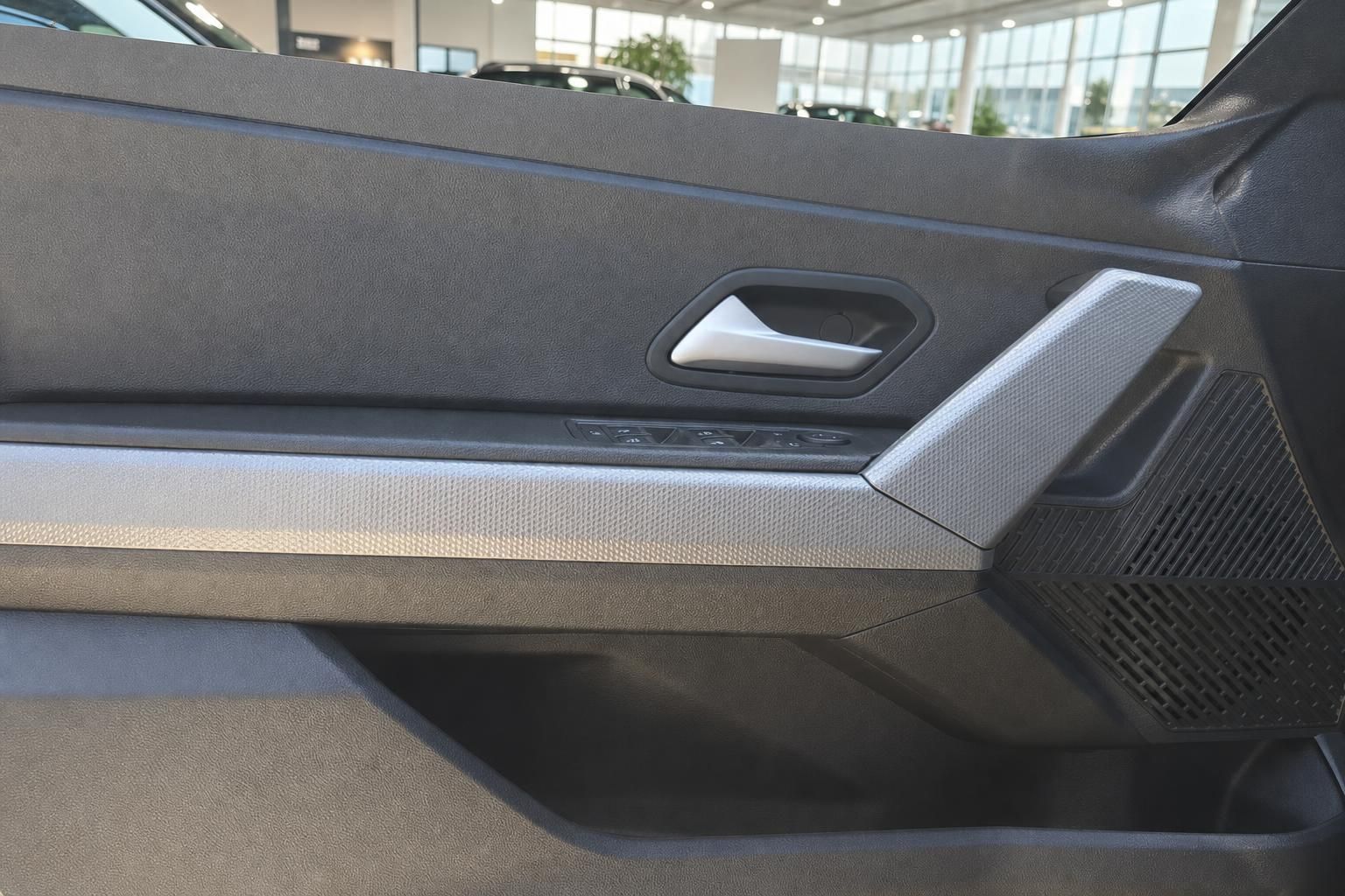 Türverkleidung mit Fensterheber-Bedienung und Griff im Fahrzeuginnenraum