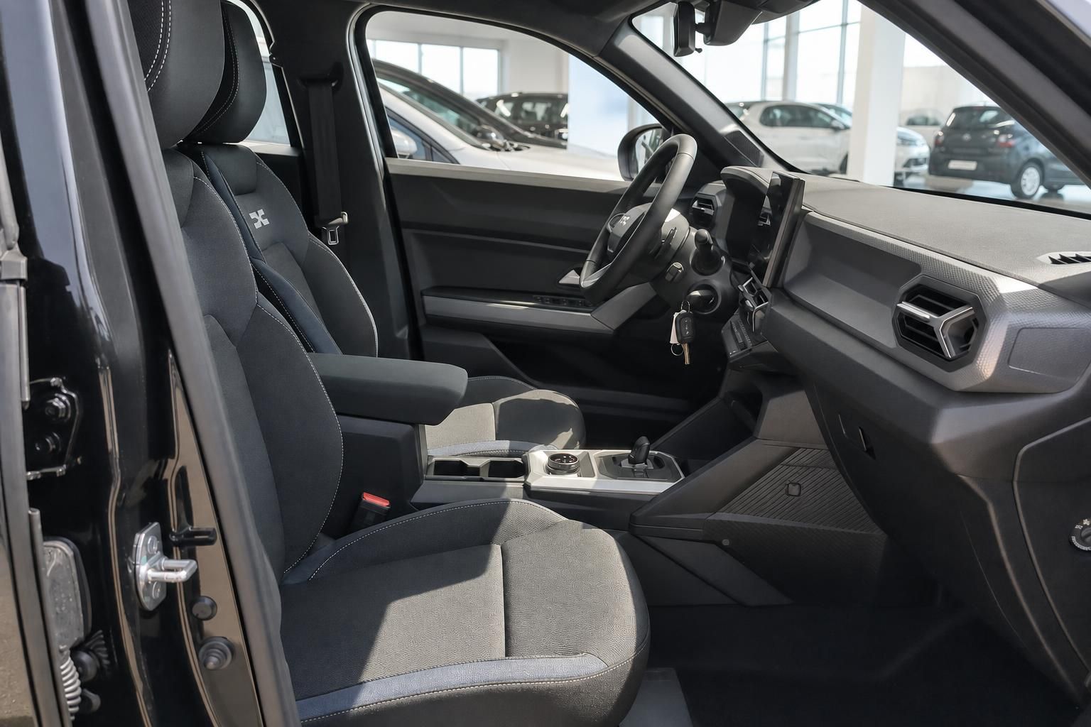 Fahrzeuginnenraum mit schwarzen Sitzen und modernem Cockpit im Autohaus
