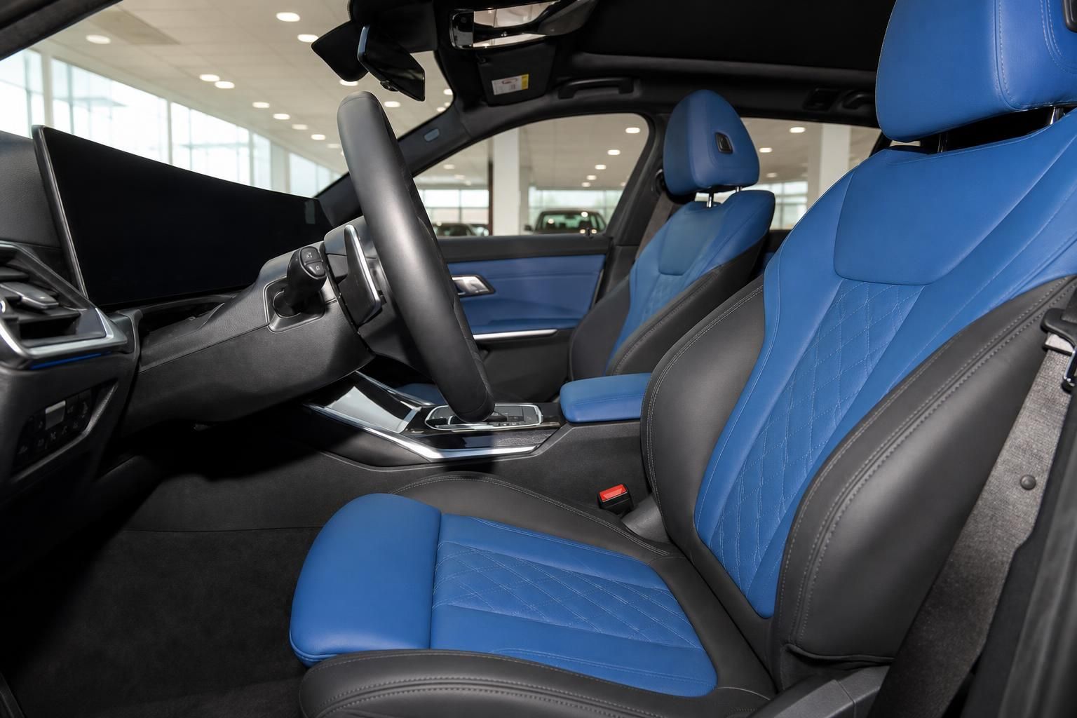 BMW Innenraum Vordersitze mit blauem Leder, Mittelkonsole und Automatikgetriebe im Autohaus