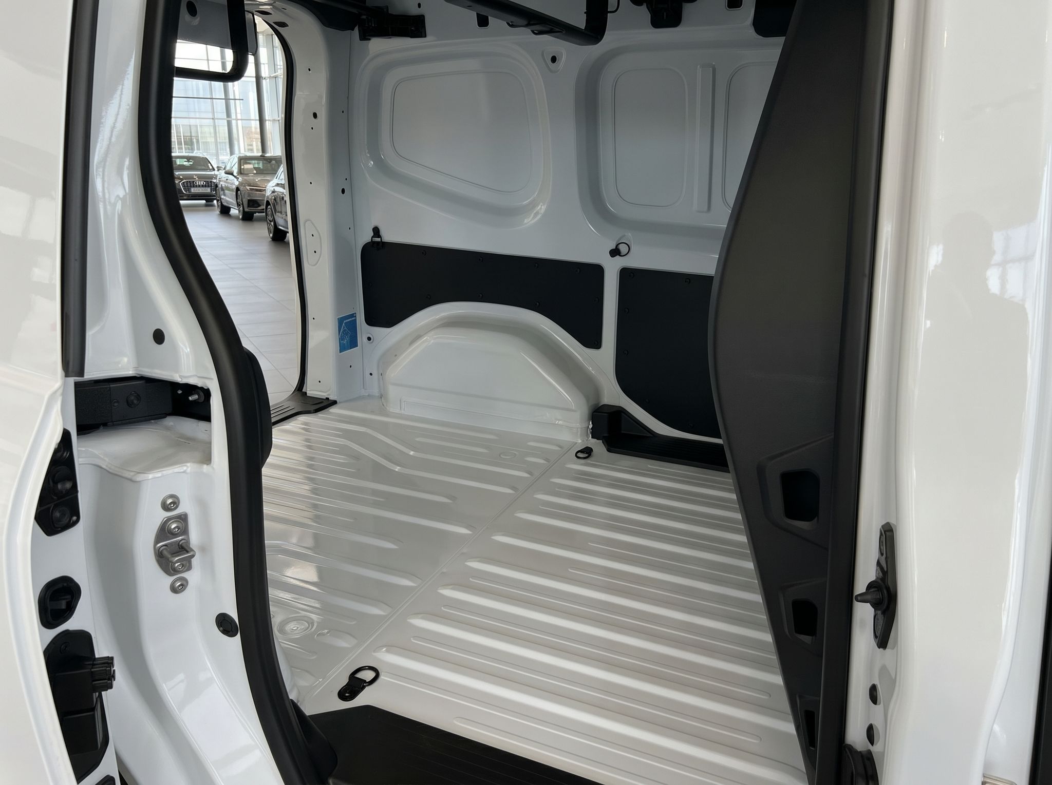 Weißer Transporter Laderaum mit Riffelblech-Boden und schwarzen Seitenschutzplatten