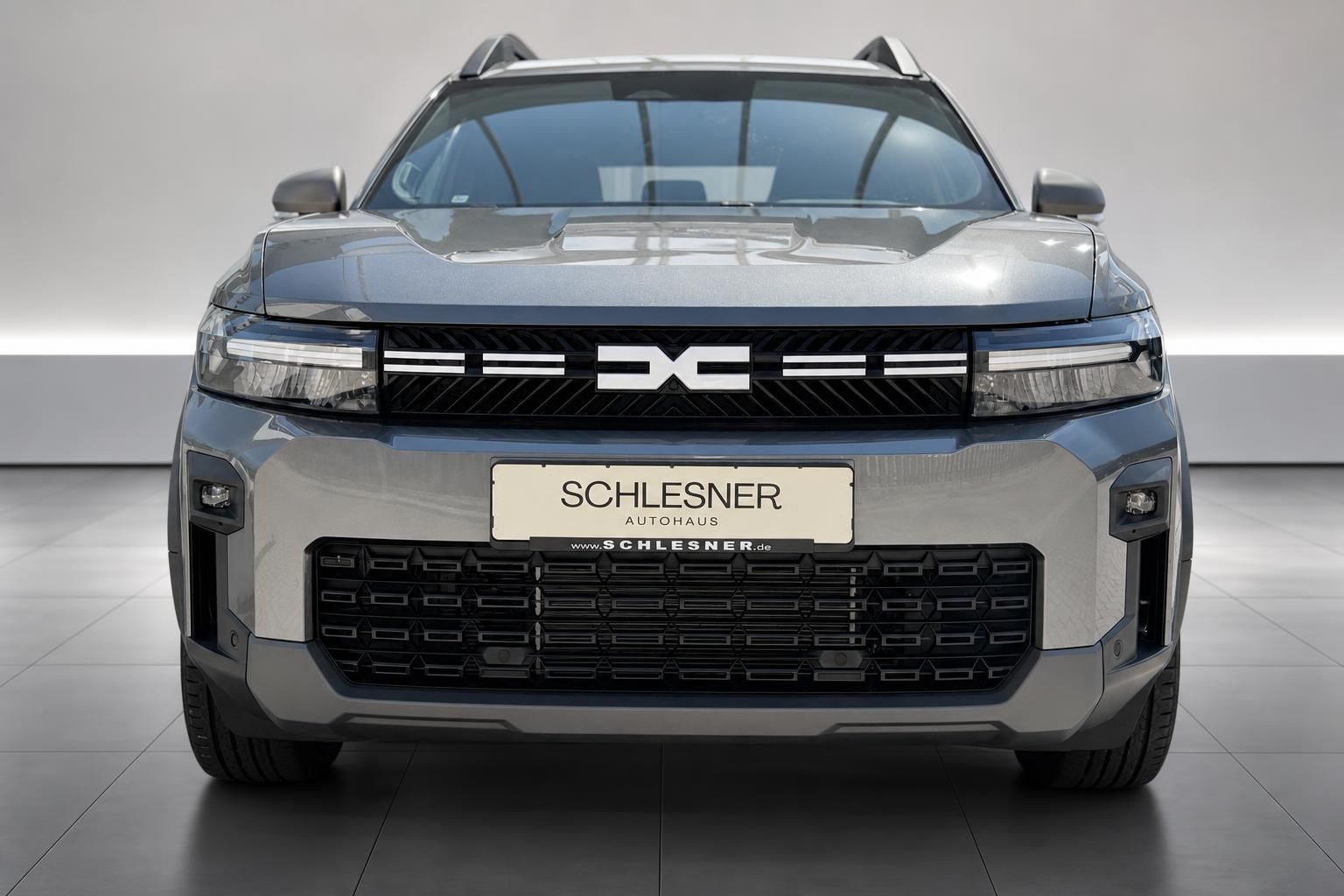 Dacia SUV grau, direkte Frontansicht mit Kuehlergrill