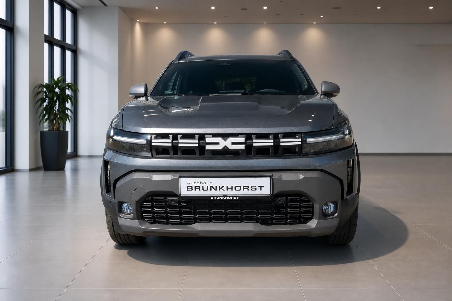 Dacia SUV grau Frontansicht mit LED-Scheinwerfern im Autohaus