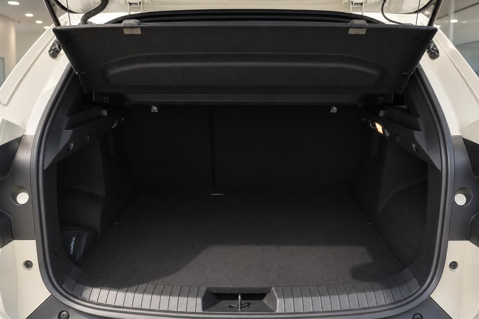 Geräumiger Kofferraum eines weißen SUV mit aufgeklappter Heckklappe und schwarzer Auskleidung