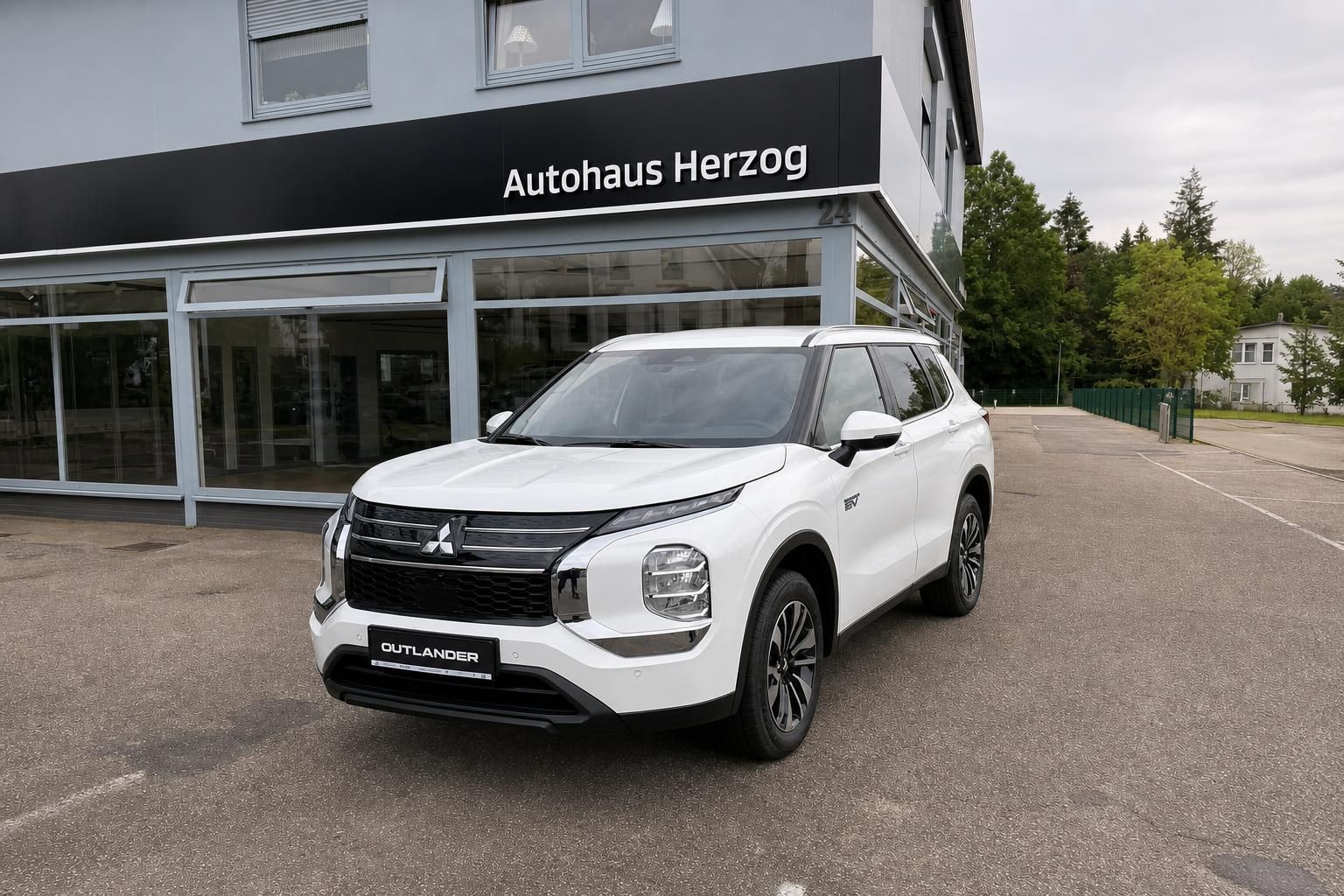 Mitsubishi Outlander weiß Frontansicht vor Autohaus Herzog
