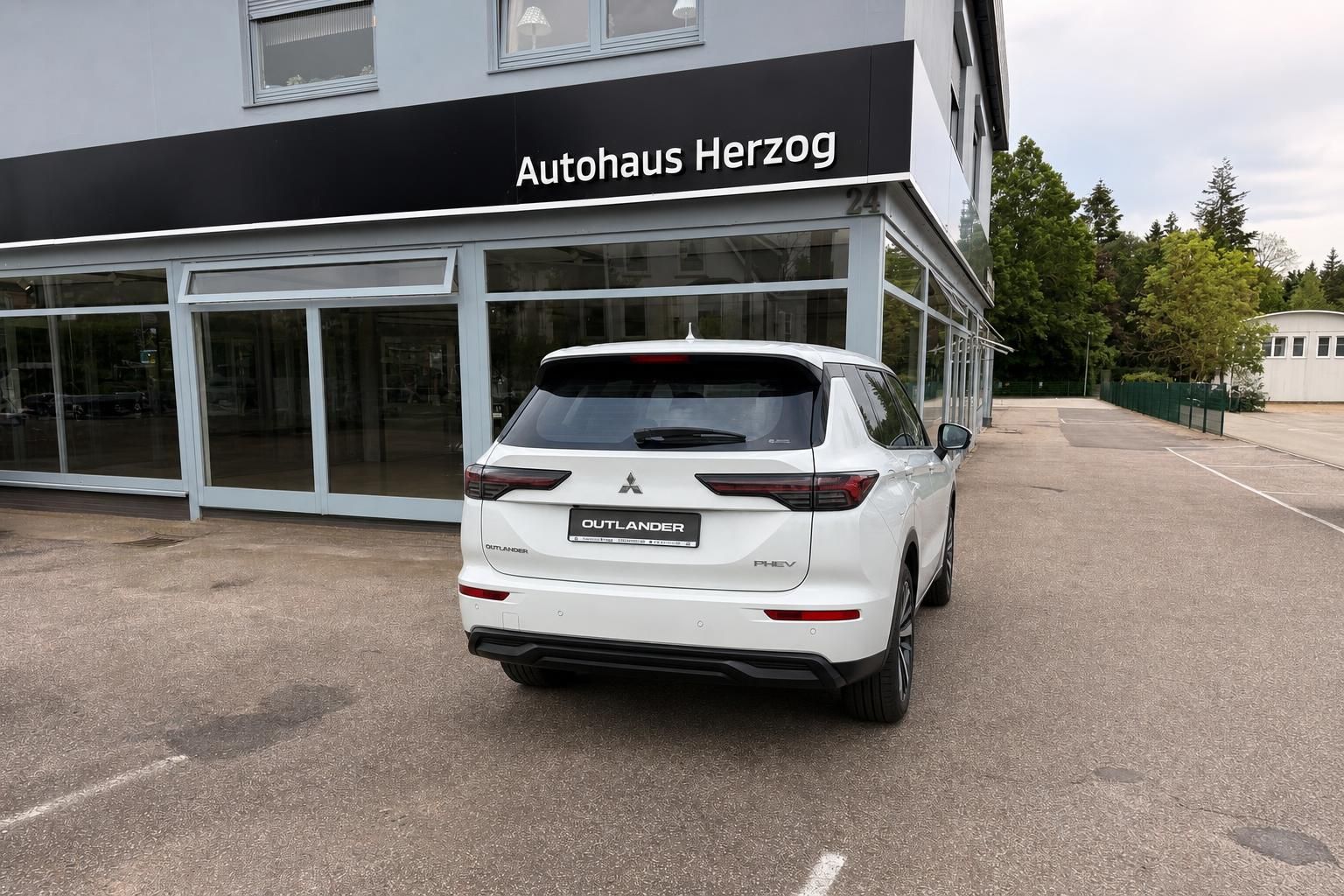 Mitsubishi Outlander PHEV weiß Heckansicht auf Hofeinfahrt