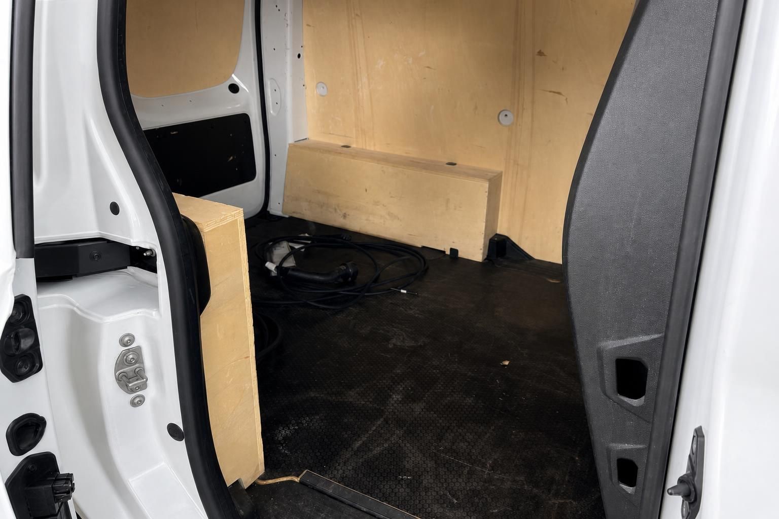 Laderaum eines Transporters mit Holzverkleidung und Kabeln auf dem Boden
