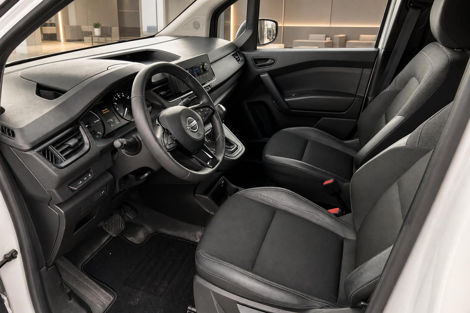 Nissan Townstar Innenraum - schwarze Sitze, Lenkrad und Armaturenbrett mit Touchscreen