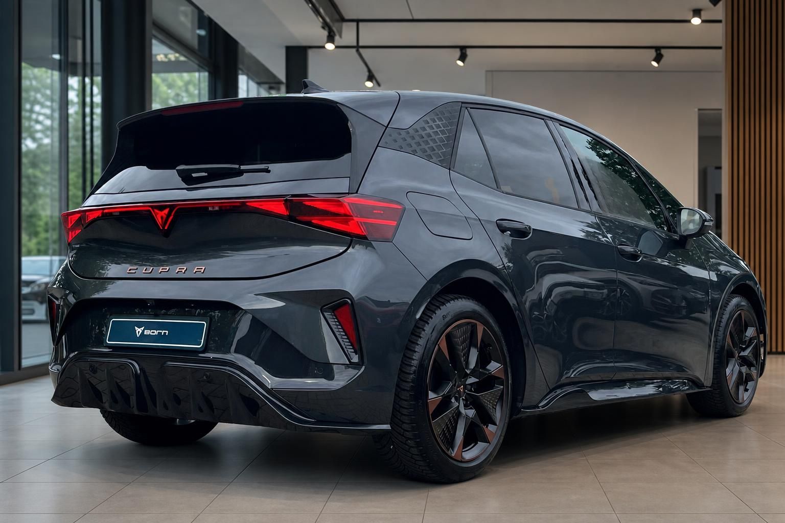 Cupra Born grau, Seiten-Heckansicht mit Alufelgen im Showroom