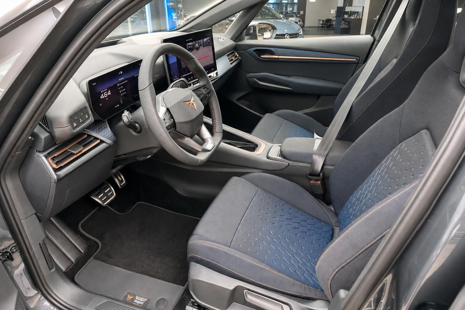 Fahrersitz und Cockpit mit Lenkrad und digitalen Displays im Innenraum