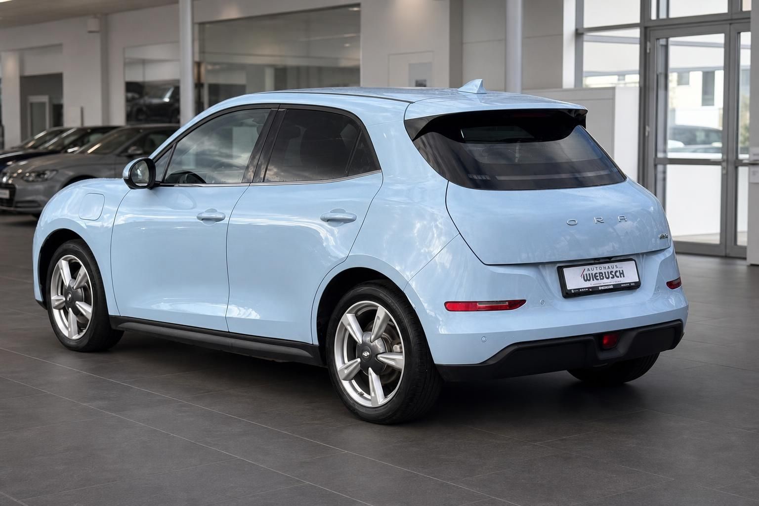 ORA Elektroauto hellblau - Heckansicht mit schwarzem Panoramadach und modernem Design