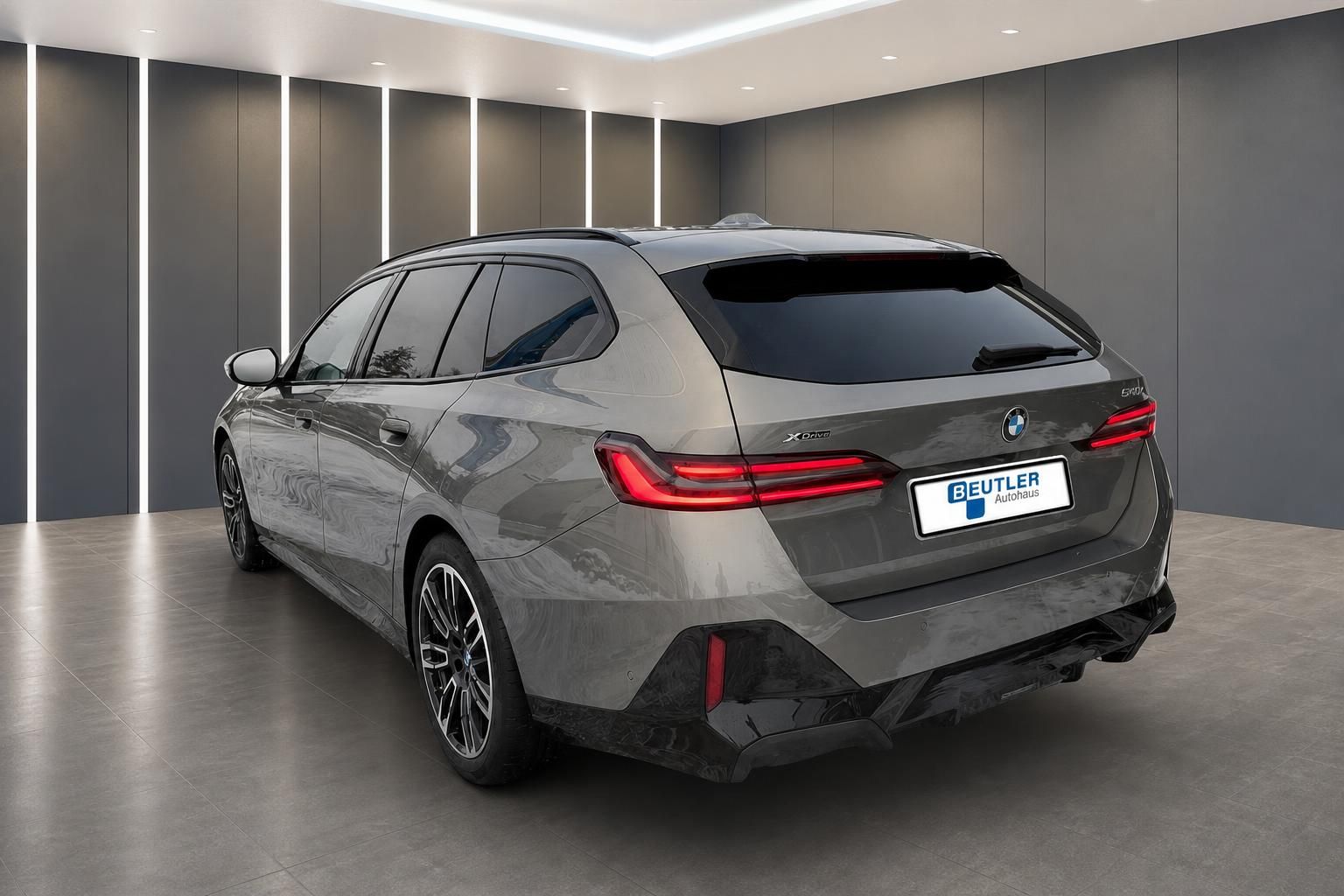 BMW 5er Touring 540d xDrive in Grau, Heckansicht in der Ausstellung