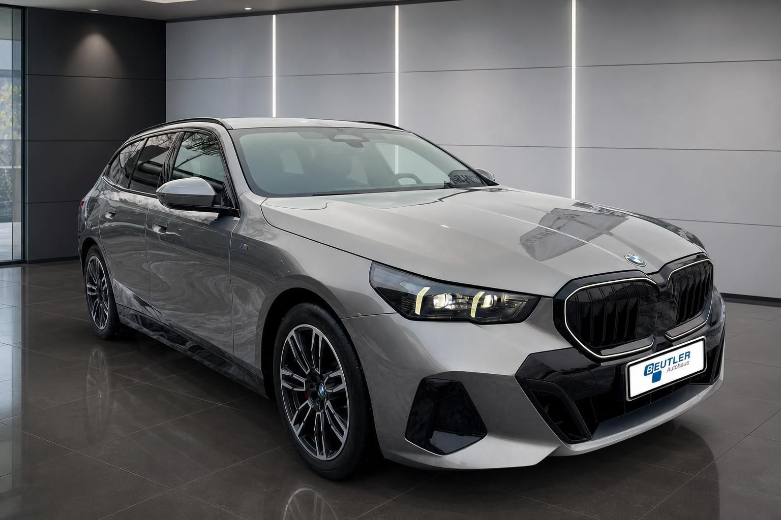 BMW 5er Touring Frontansicht schräg, silberfarben im Showroom