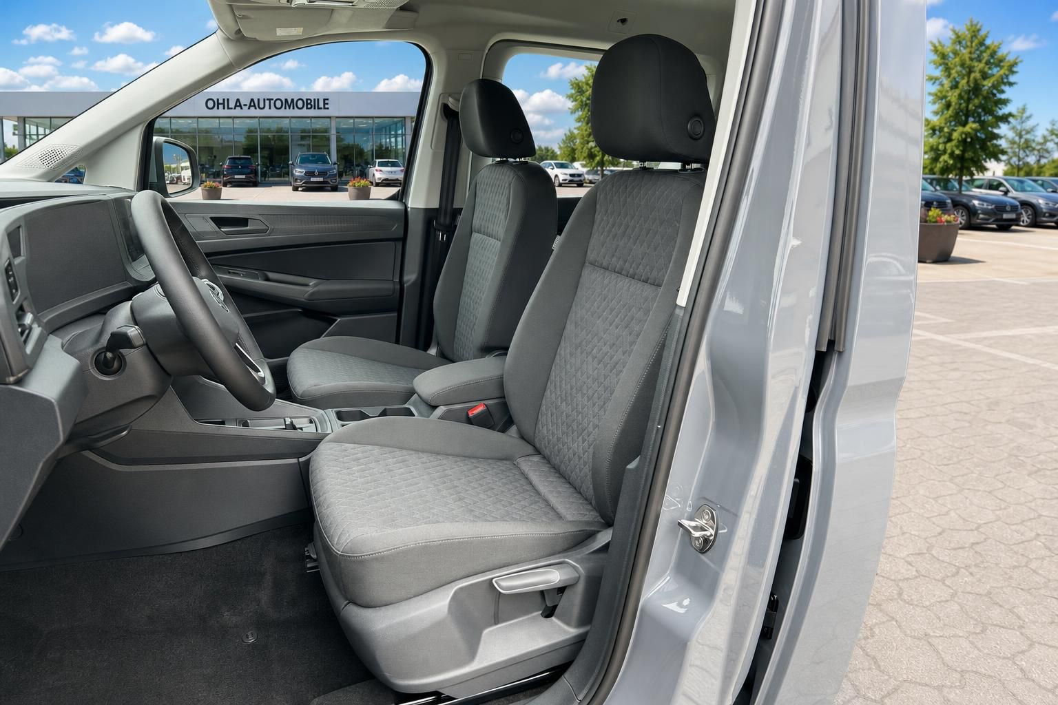 VW Caddy Innenraum mit grauen Stoffsitzen und Lederlenkrad