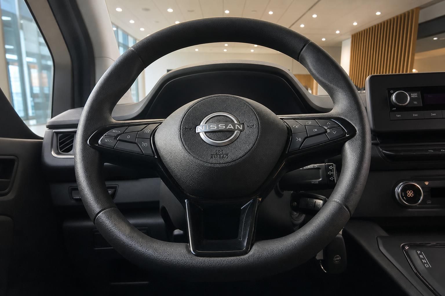 Nissan Lenkrad mit Multifunktionstasten und Nissan-Logo im Fahrzeuginneren