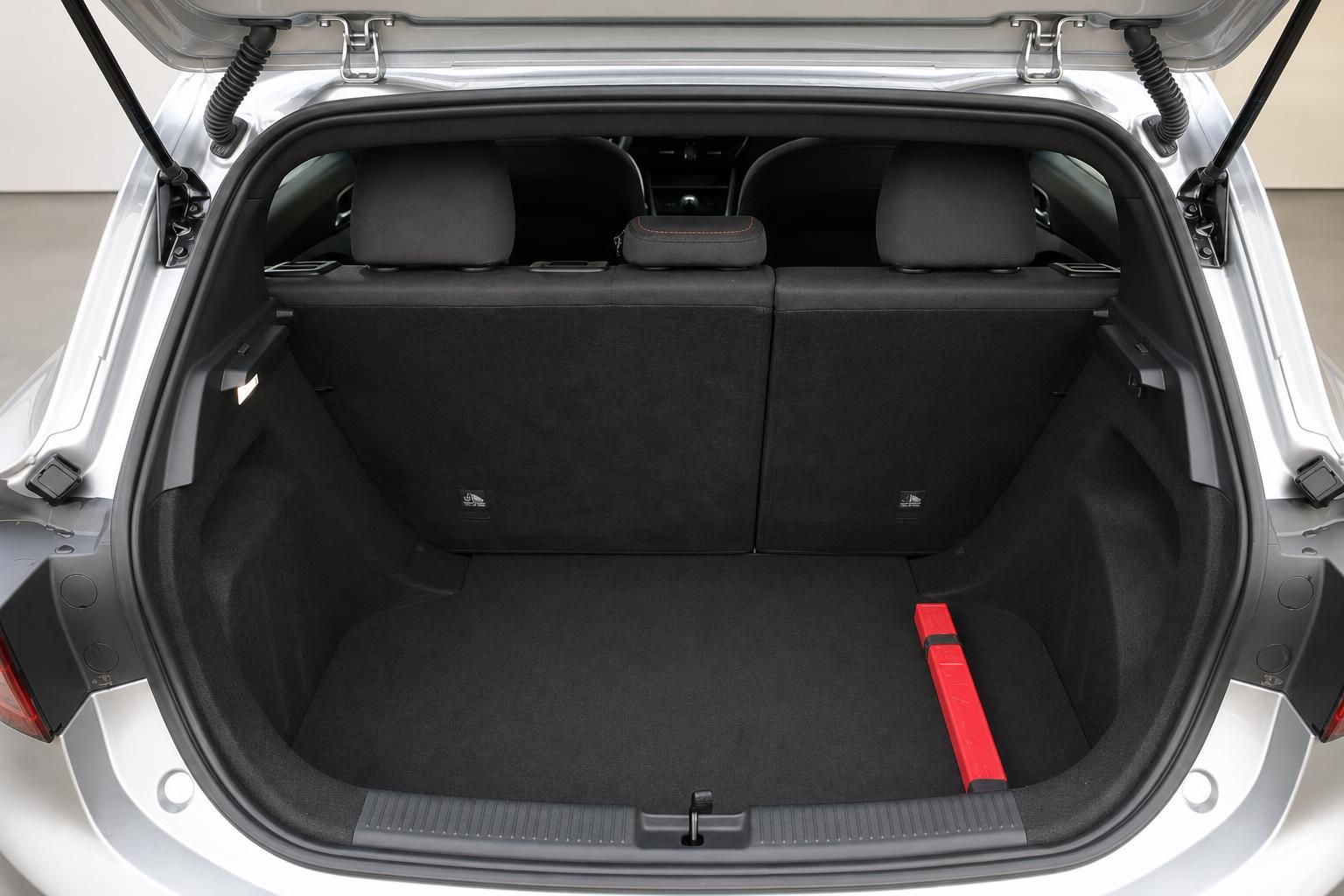 Kofferraum eines weißen Autos mit geöffneter Heckklappe und schwarzer Innenausstattung