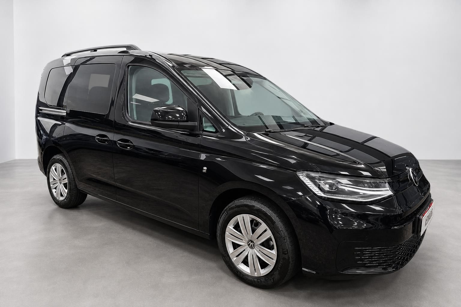 VW Caddy schwarz Frontansicht schraeg Studioaufnahme