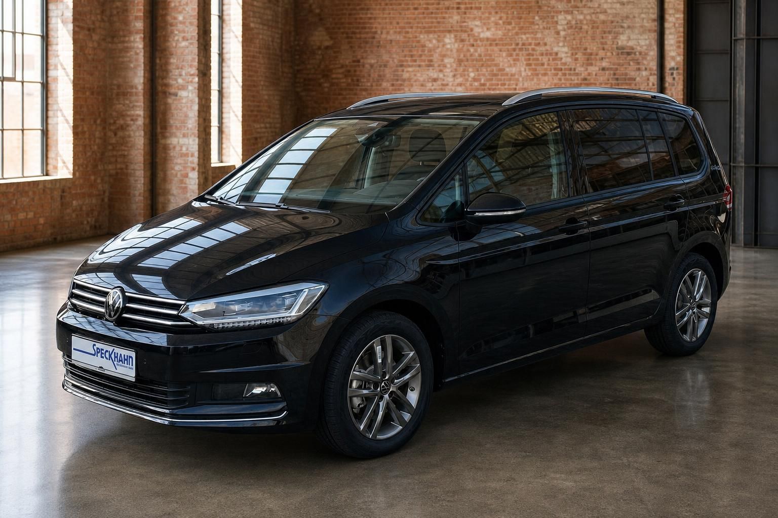 VW Touran schwarz Frontansicht seitlich vor Backsteinwand