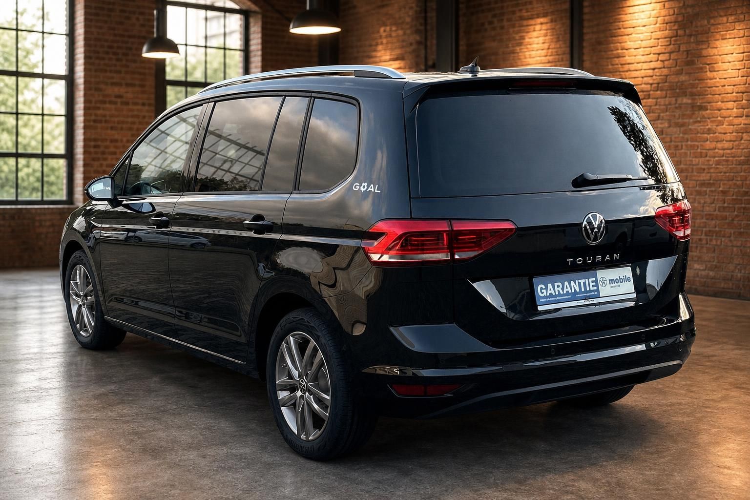 VW Touran schwarz Heckansicht seitlich in Halle mit Backsteinwand