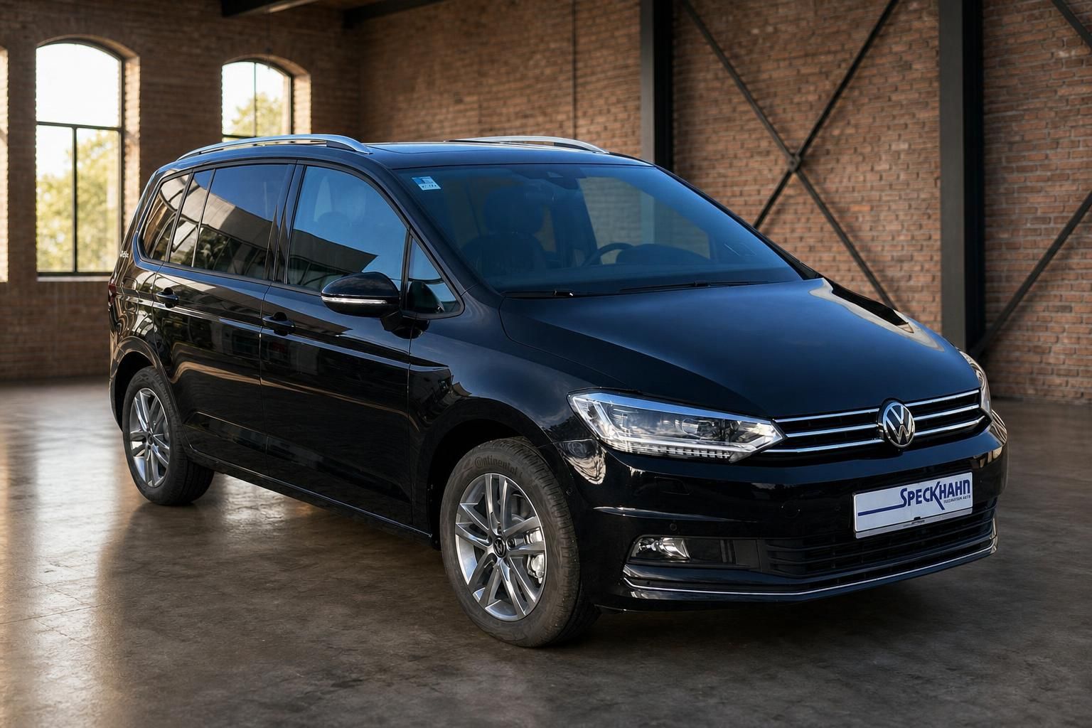 VW Touran schwarz Frontansicht schräg in Industriehalle