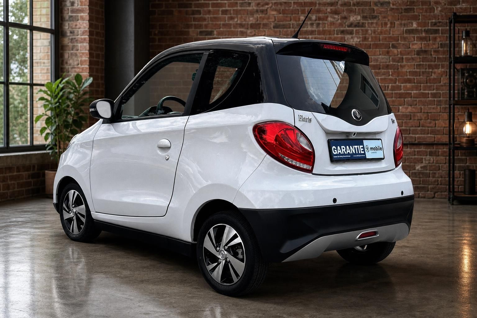 Elaris Pio Elektroauto weiss Heckansicht schraeg links im Showroom