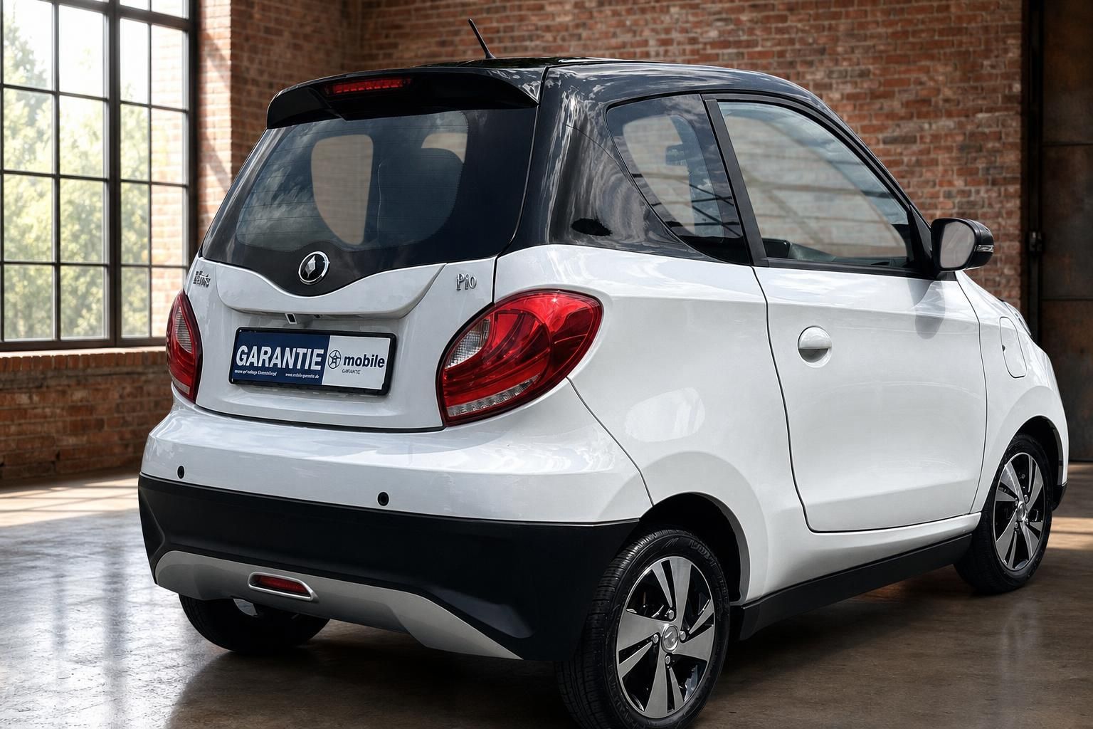 Elaris Pio Elektroauto weiss Heckansicht schraeg rechts im Showroom