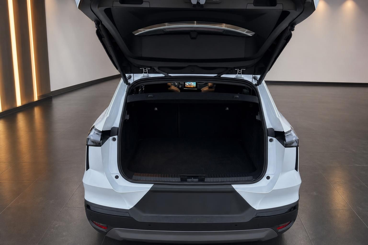 Geöffneter Kofferraum eines weißen SUV mit großzügigem Laderaum in modernem Autohaus-Showroom