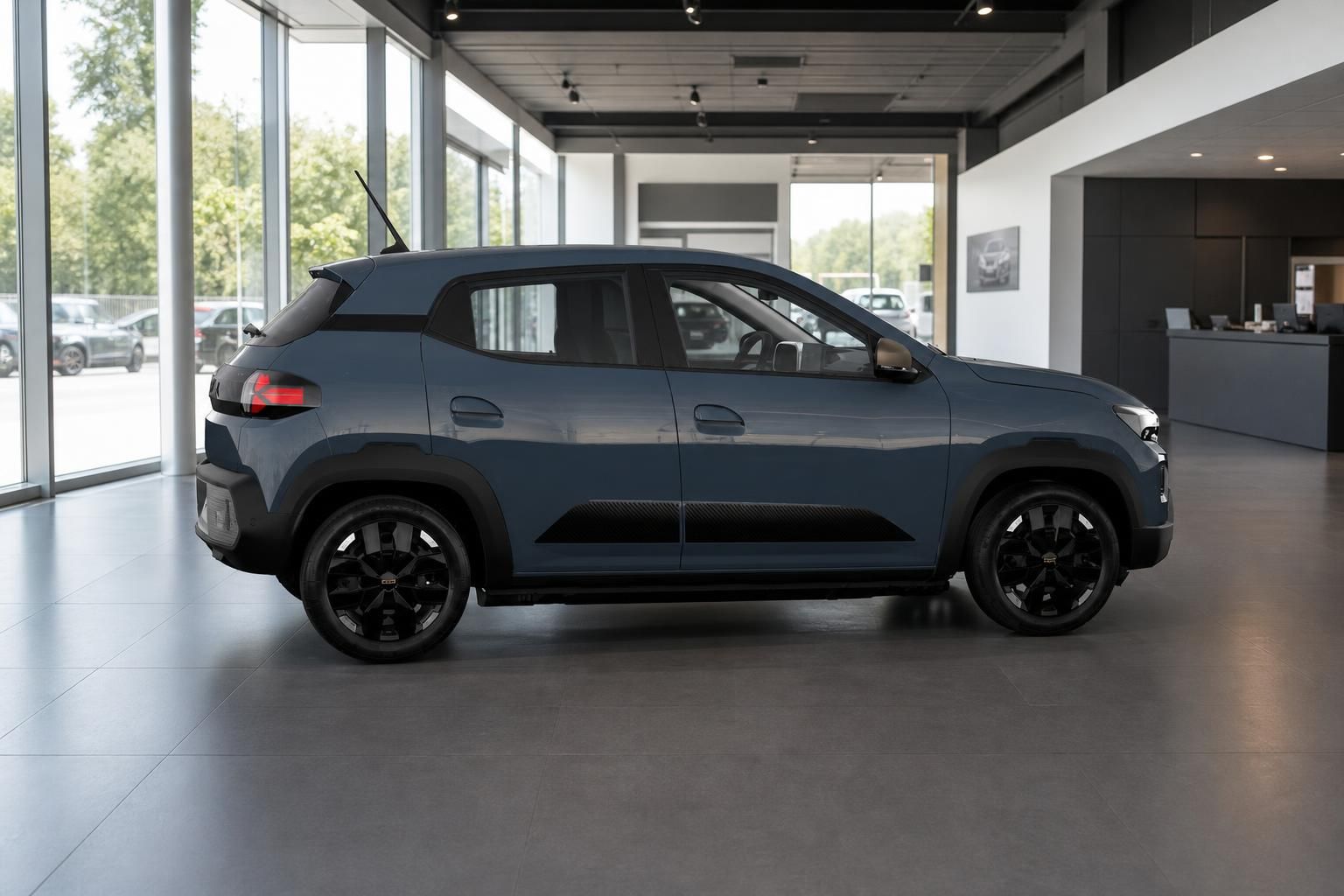 Dacia Spring blaugrau, Seitenansicht im modernen Autohaus