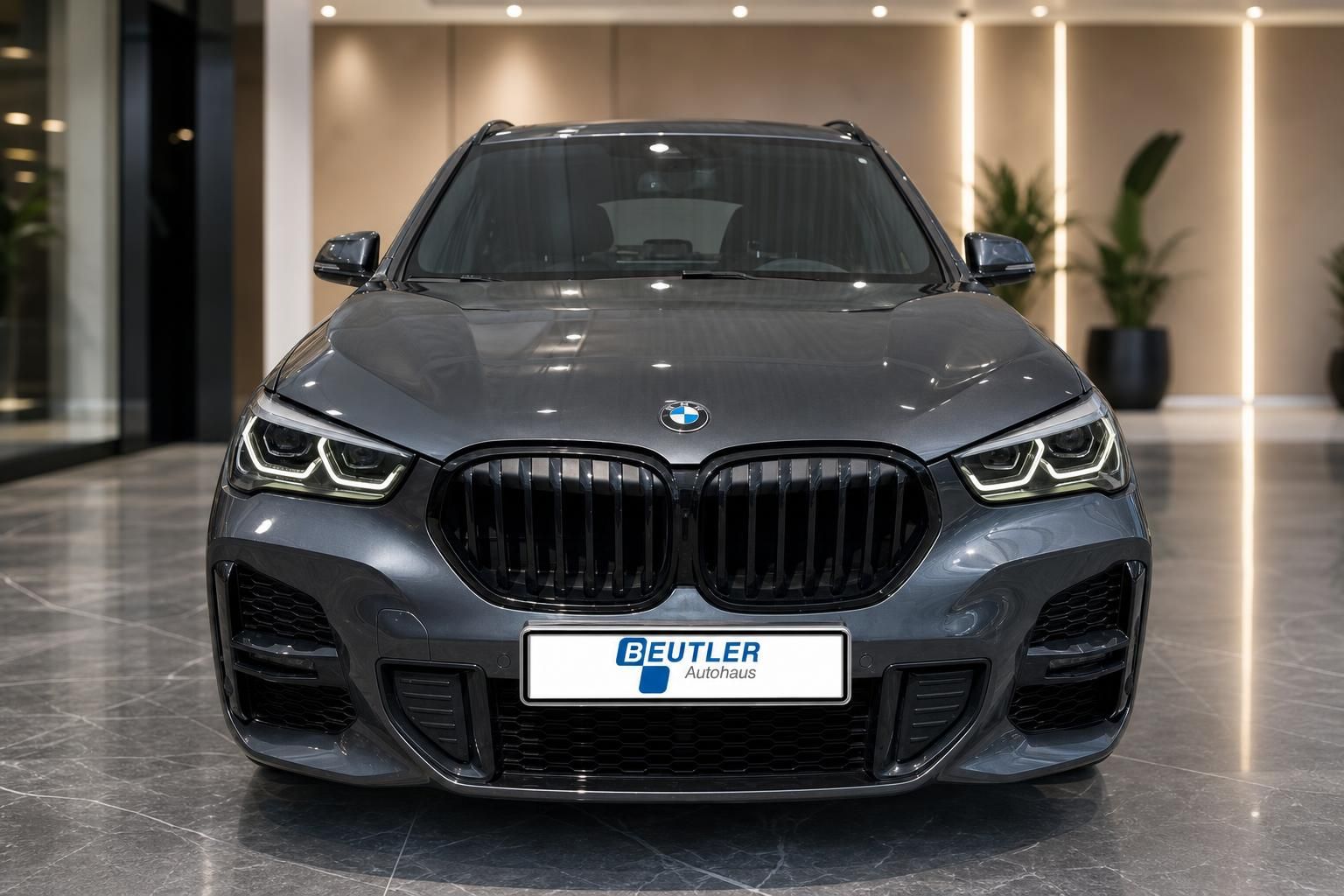 BMW X1 grau Frontansicht mit LED-Scheinwerfern im Showroom