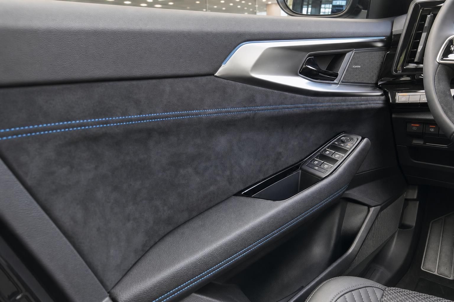 Türverkleidung mit blauer Ziernaht und Fensterheberschalter