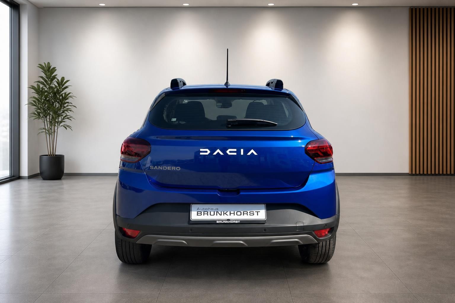 Dacia Sandero blau Heckansicht im Autohaus - Kompaktwagen mit schwarzen Kunststoffverkleidungen