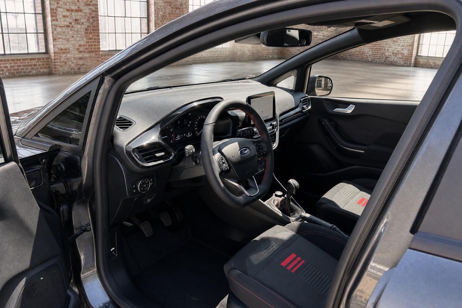 Ford Fiesta Innenraum von Fahrerseite – Lenkrad, Sitze mit roten Akzenten und Infotainment
