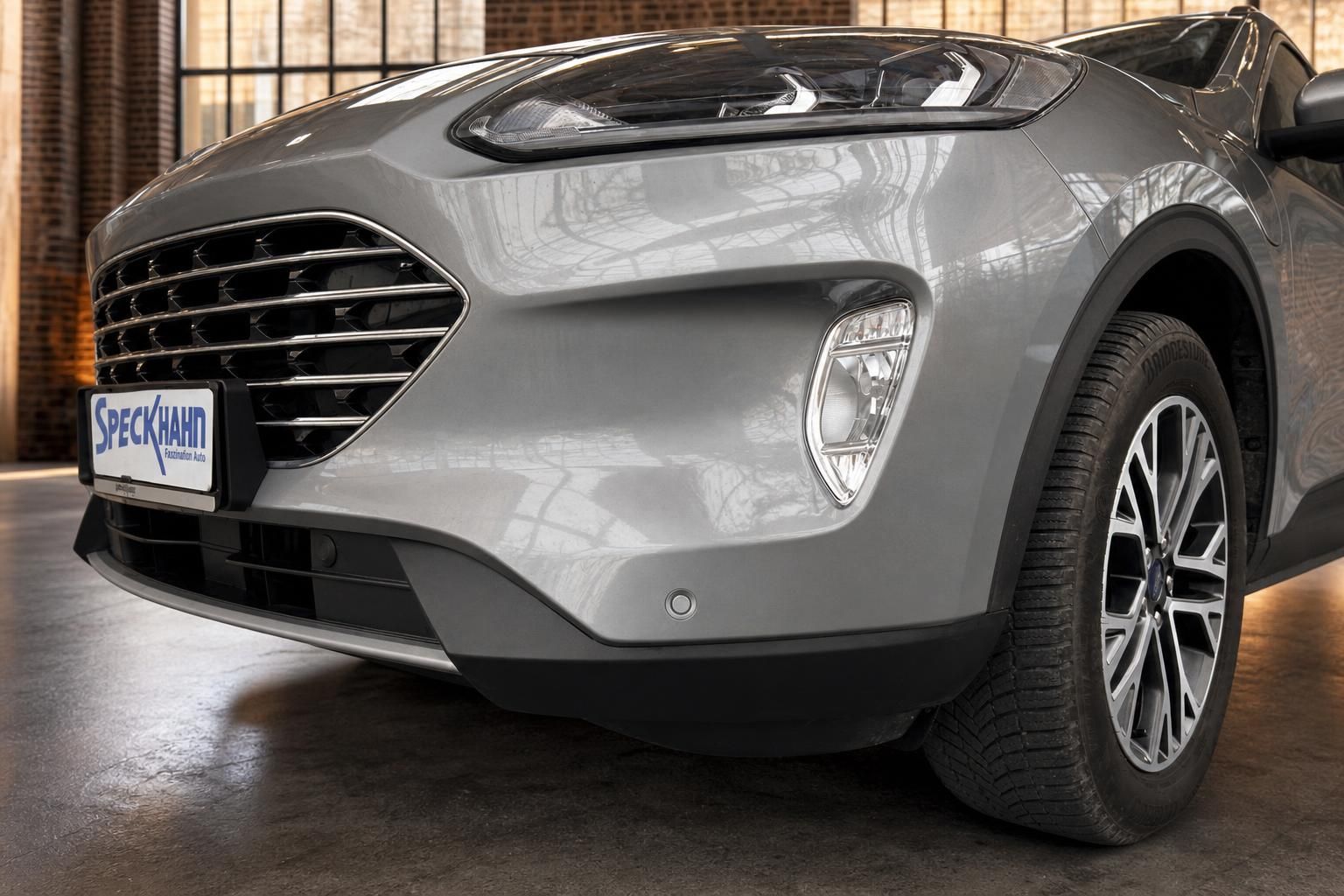 Ford Kuga Detailansicht vordere Stossstange mit Felge und Scheinwerfer
