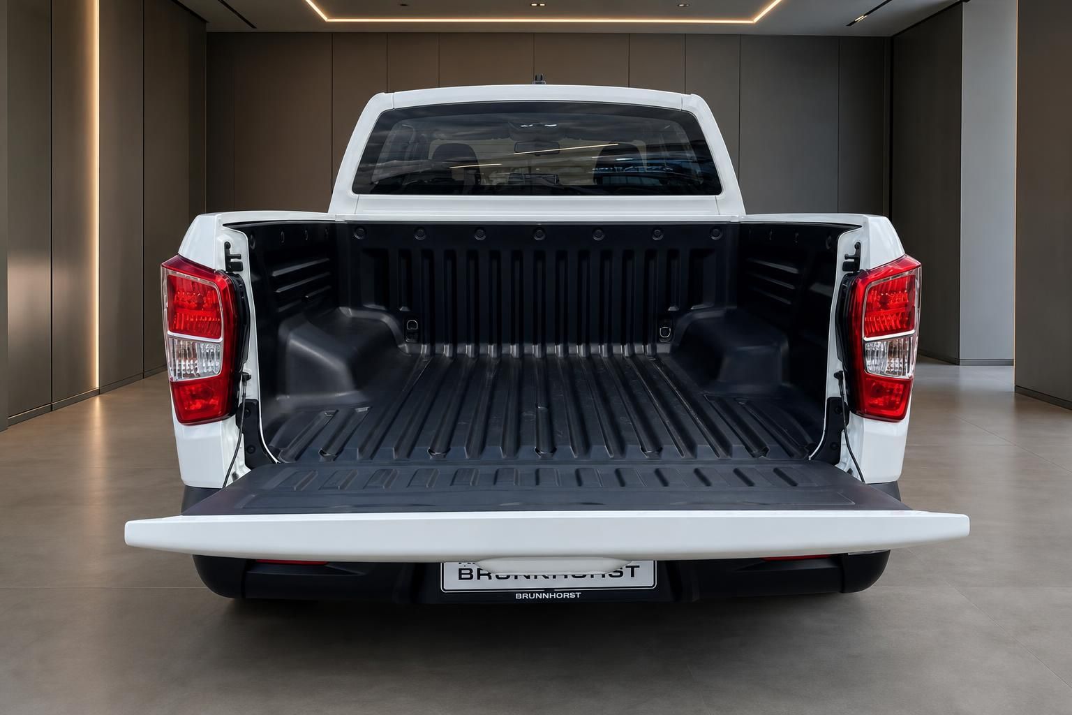 Weißer Pickup Truck mit geöffneter Ladefläche und schwarzer Auskleidung im Showroom