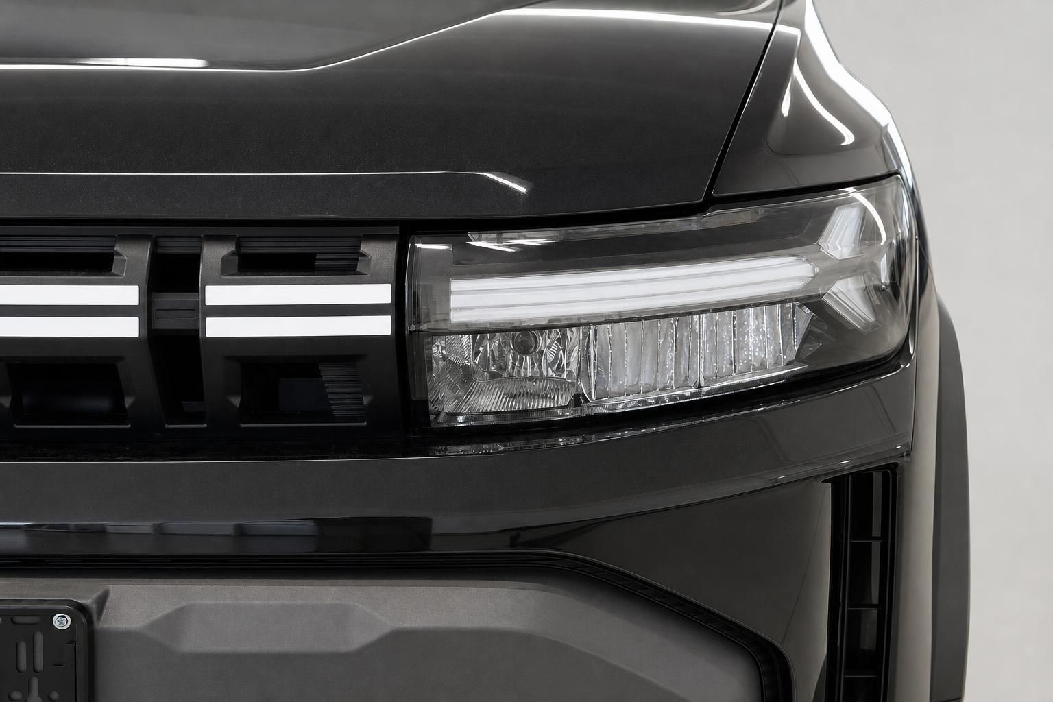 Nahaufnahme LED-Scheinwerfer und Kuehlergrill Dacia Duster in Schwarz