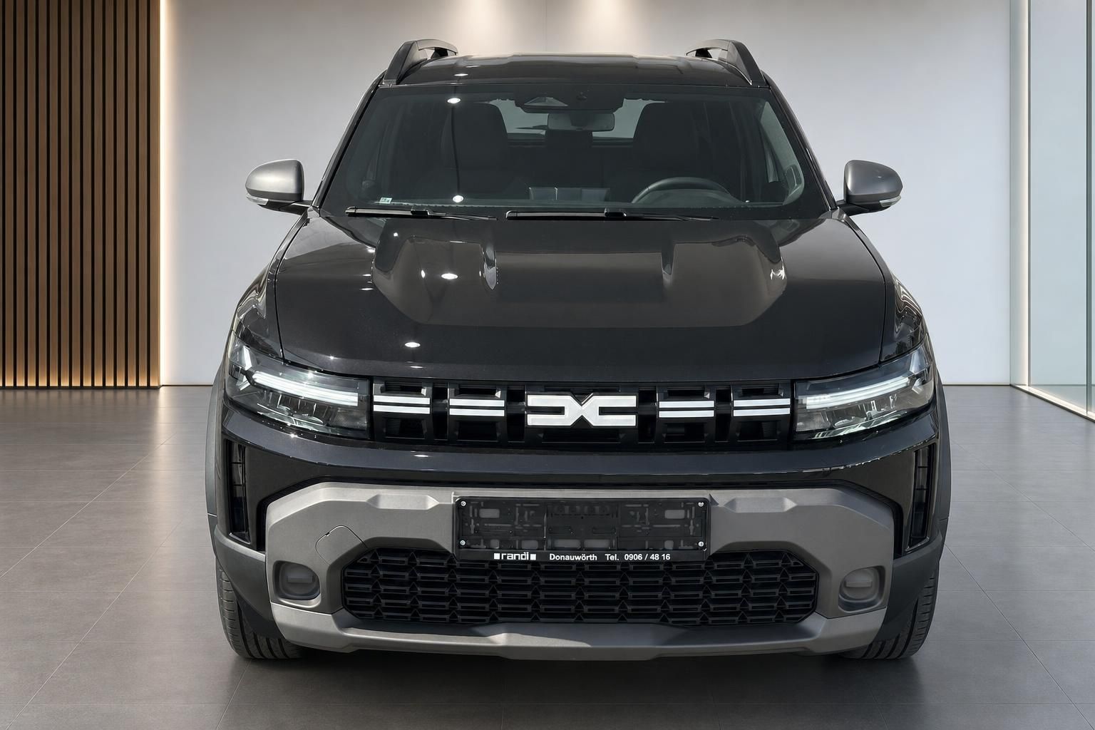 Dacia SUV schwarz, direkte Frontalansicht im Autohaus