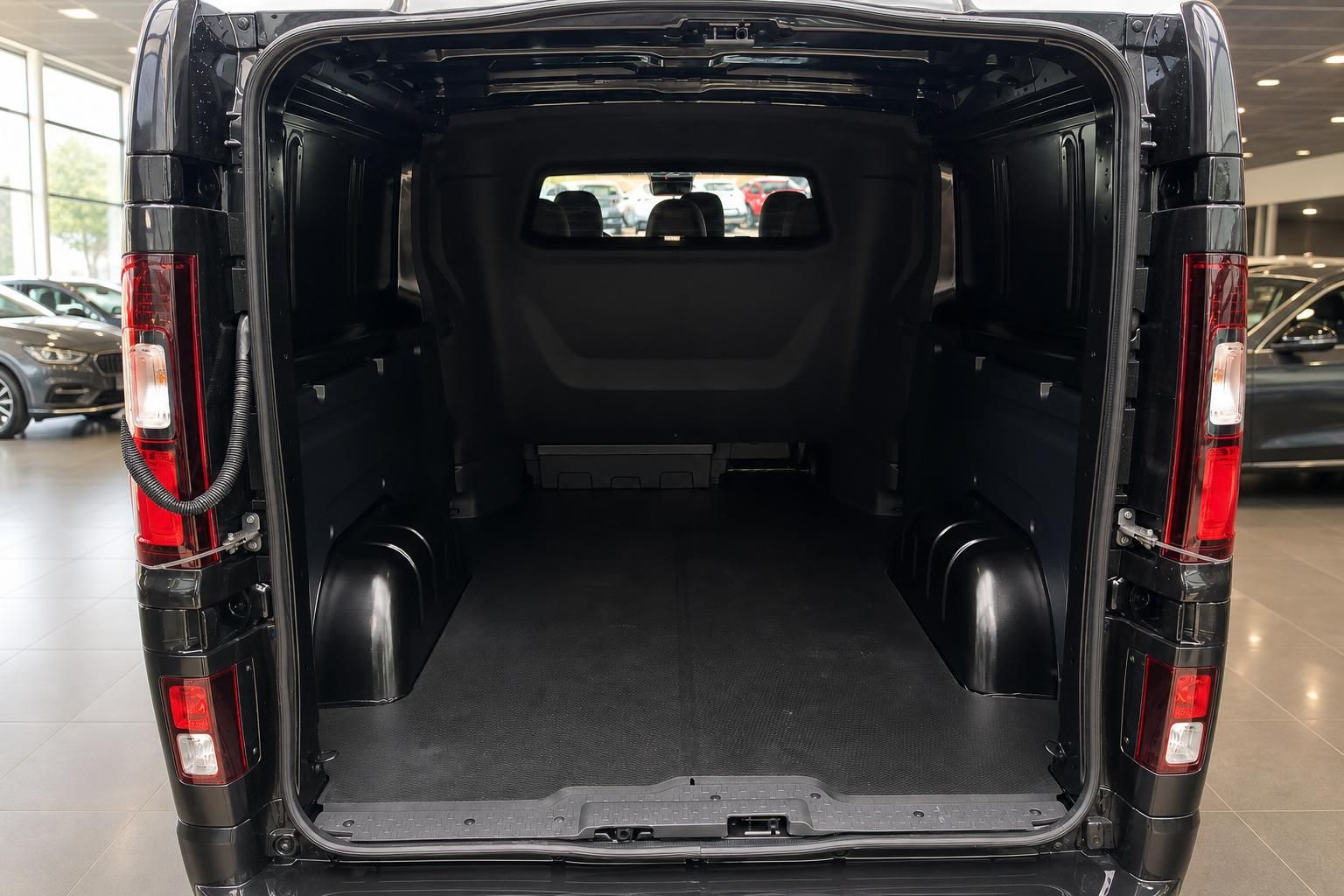 Geräumiger Laderaum eines schwarzen Transporters mit offenen Hecktüren im Autohaus