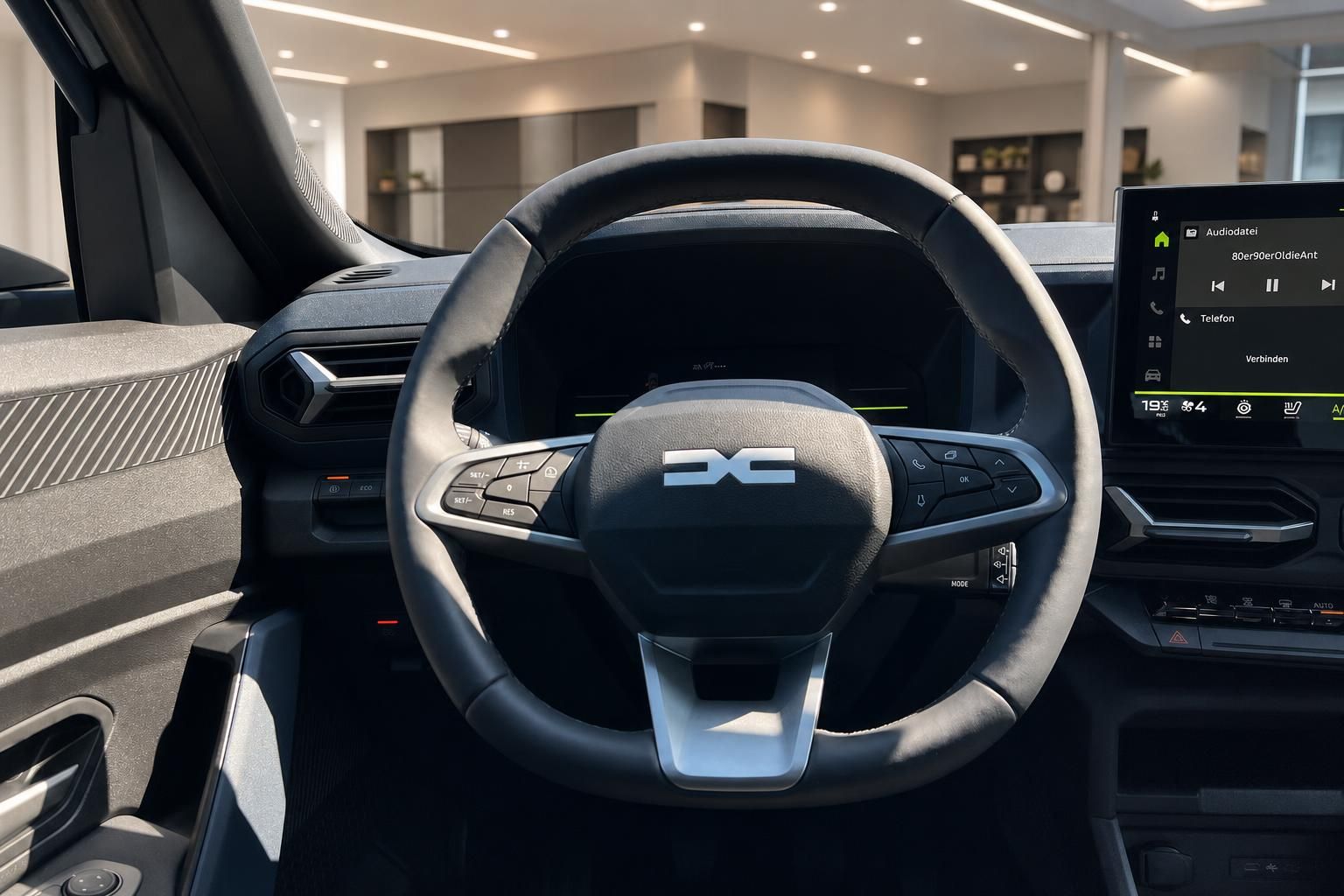 Lenkrad mit Bedienelementen und Digitalanzeige im Fahrzeuginnenraum