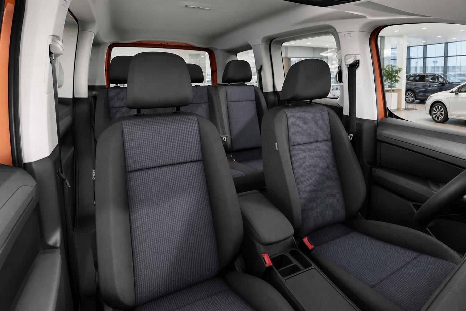 Innenraum eines VW Vans mit Sitzreihen und Blick durch offene Türen